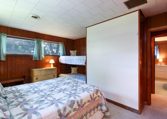 carpeted bedroom with wood walls