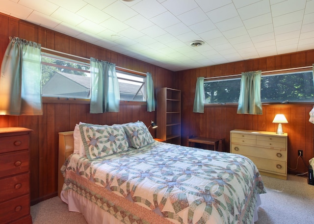 carpeted bedroom featuring wooden walls