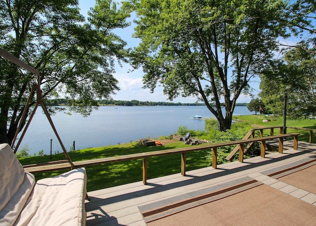 wooden terrace featuring a lawn and a water view