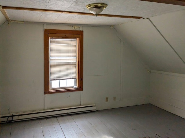 additional living space featuring hardwood / wood-style flooring, a baseboard radiator, and vaulted ceiling