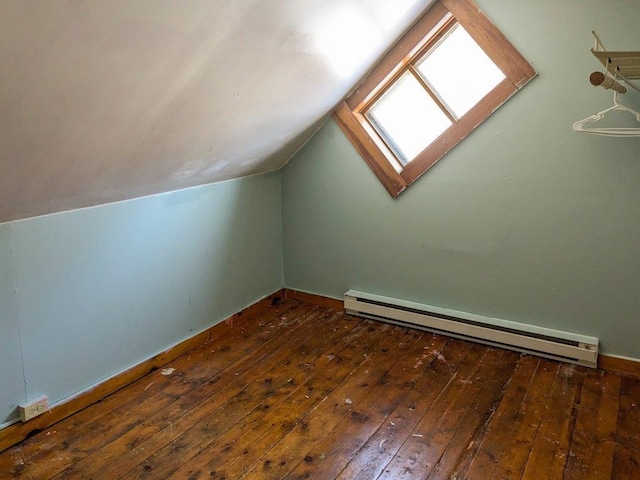 additional living space with a baseboard radiator, dark hardwood / wood-style floors, and lofted ceiling with skylight