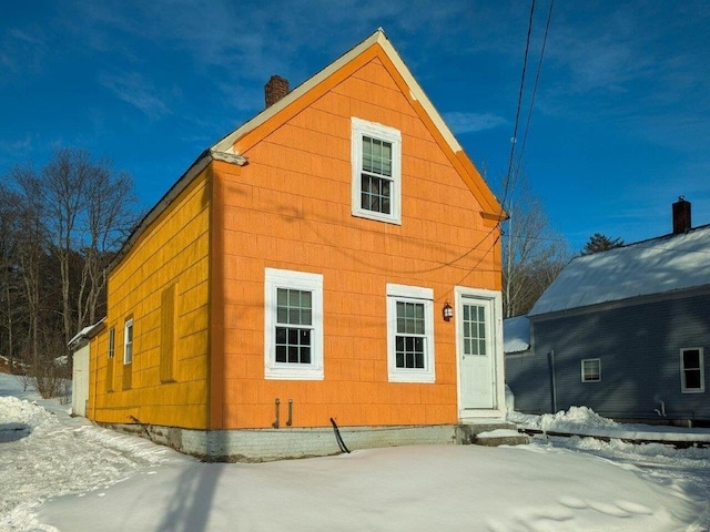 view of snow covered rear of property