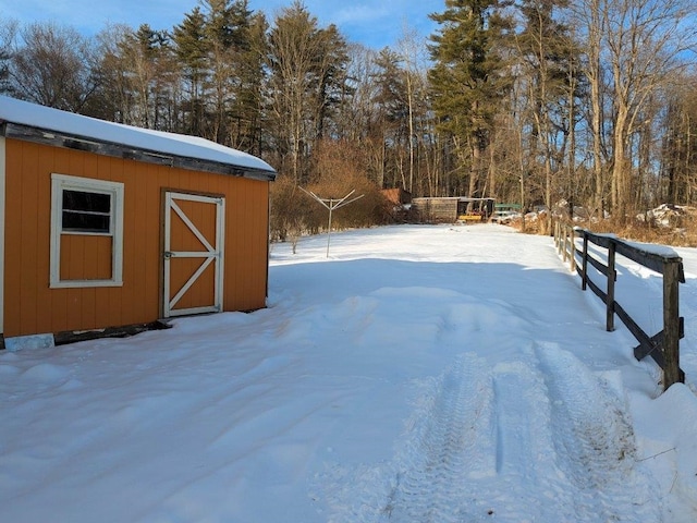 yard layered in snow with an outdoor structure