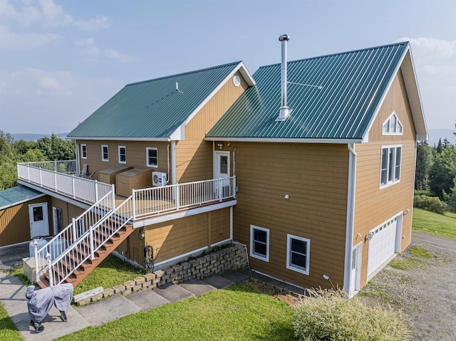 rear view of house with a garage and a deck