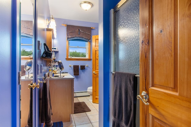 bathroom with baseboard heating, tile patterned flooring, an enclosed shower, vanity, and toilet