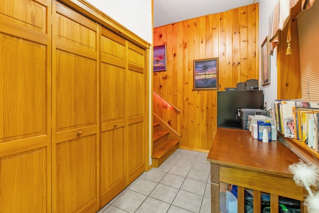 interior space featuring light tile patterned floors and wooden walls