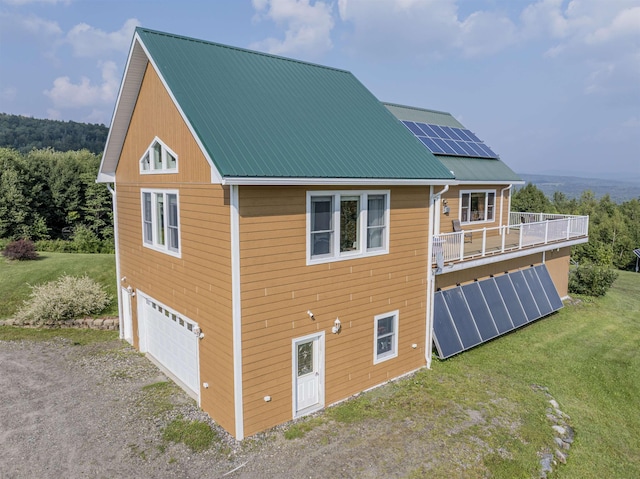 back of house featuring a garage and solar panels