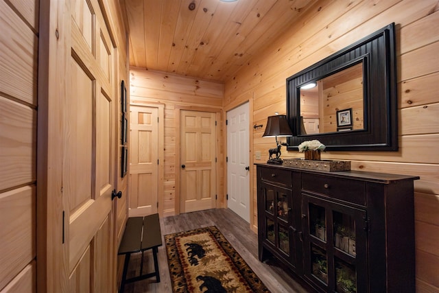 doorway to outside with wood walls, dark hardwood / wood-style floors, and wooden ceiling