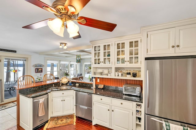 44 Winnicoash St, Laconia, NH 03246 - kitchen with dark stone countertops, sink, kitchen peninsula, and appliances with stainless steel finishes