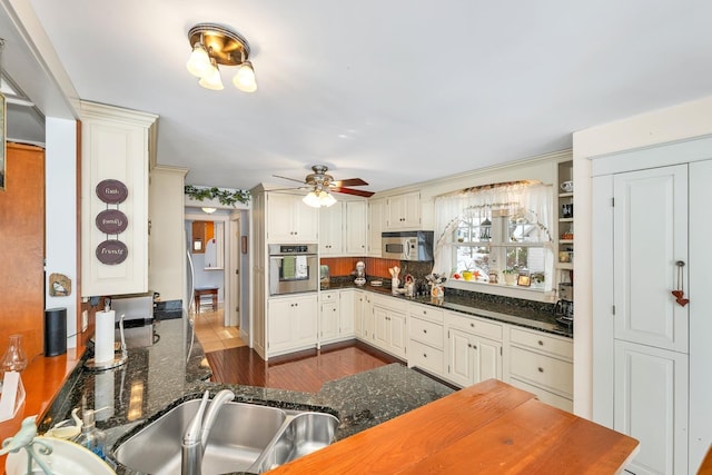 44 Winnicoash St, Laconia, NH 03246 - kitchen with dark stone countertops, hardwood / wood-style flooring, stainless steel appliances, and kitchen peninsula