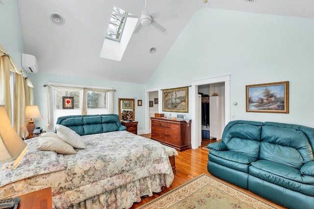 44 Winnicoash St, Laconia, NH 03246 - bedroom featuring a spacious closet, a skylight, a wall mounted AC, high vaulted ceiling, and light hardwood / wood-style flooring