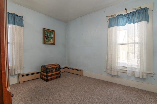 carpeted spare room with baseboard heating and a wealth of natural light