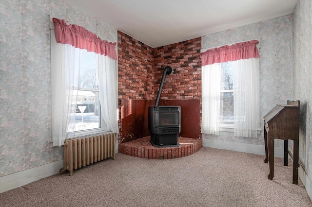 carpeted living room featuring radiator heating unit and a wood stove