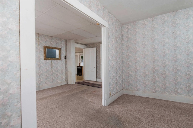 empty room with carpet floors and a paneled ceiling