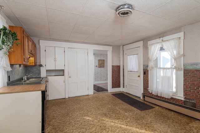 entryway featuring a baseboard heating unit, a paneled ceiling, and sink