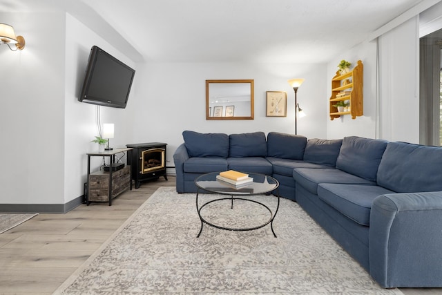 living room featuring light hardwood / wood-style flooring and a wood stove