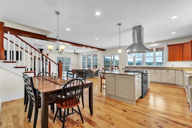 dining area featuring beam ceiling, ceiling fan with notable chandelier, and light hardwood / wood-style floors