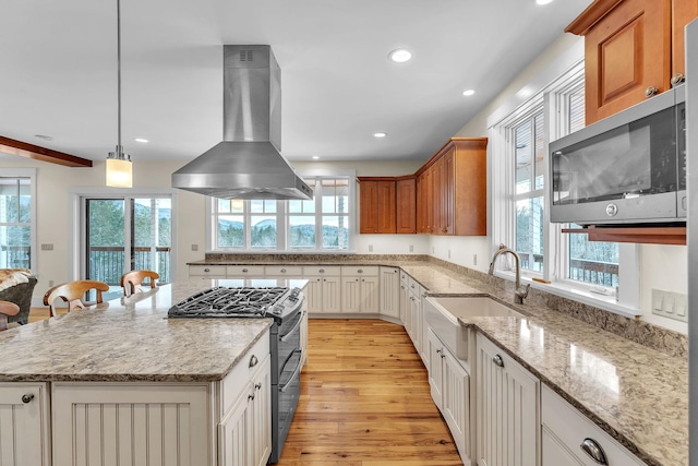 kitchen with white cabinetry, appliances with stainless steel finishes, and island exhaust hood