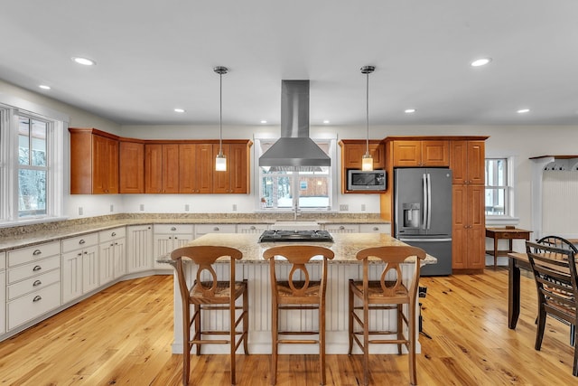 kitchen with white cabinetry, island range hood, stainless steel appliances, and decorative light fixtures