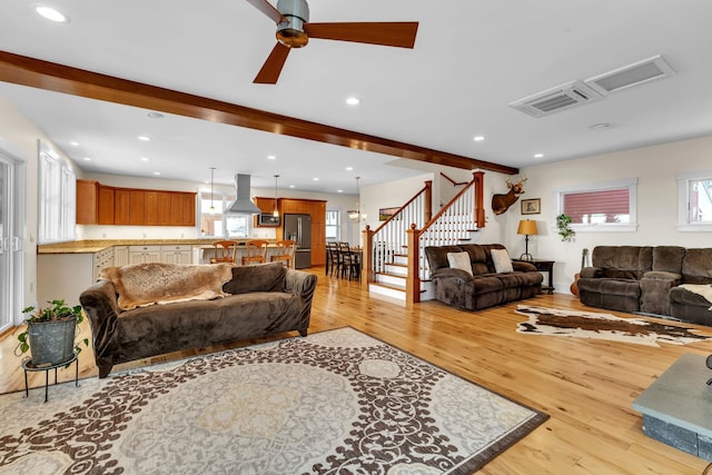 living room featuring beam ceiling, ceiling fan, and light hardwood / wood-style floors