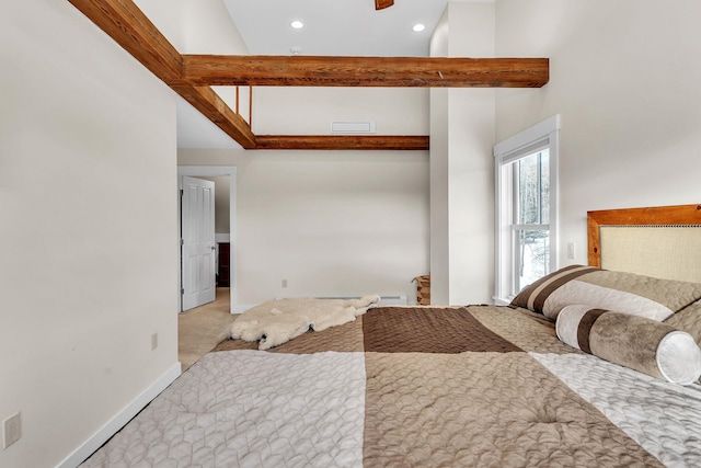 bedroom with a high ceiling, light colored carpet, and beam ceiling