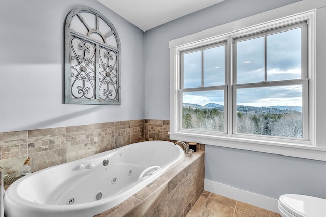 bathroom featuring toilet and tiled tub