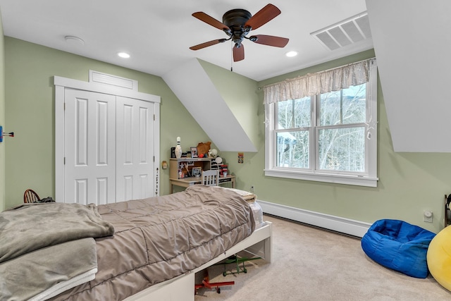 bedroom with vaulted ceiling, baseboard heating, ceiling fan, a closet, and light colored carpet