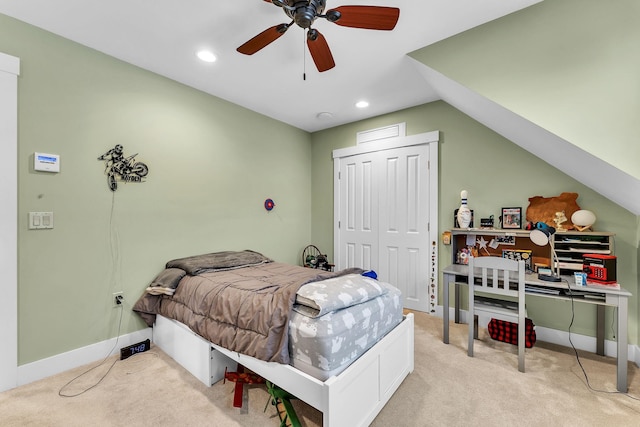 bedroom with vaulted ceiling, light colored carpet, and a closet