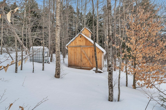 yard layered in snow featuring a storage unit