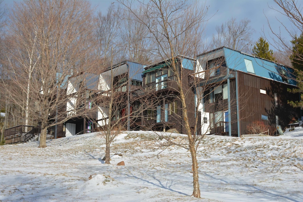 view of snow covered back of property