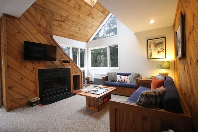 carpeted living room featuring wooden walls, high vaulted ceiling, and wooden ceiling