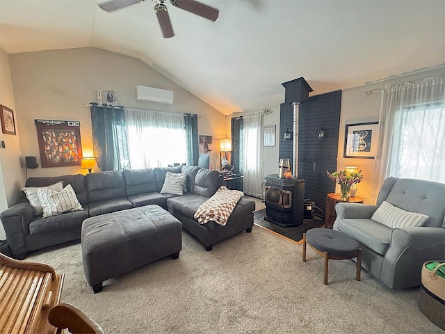 carpeted living room featuring vaulted ceiling, a wood stove, a wall mounted AC, and ceiling fan