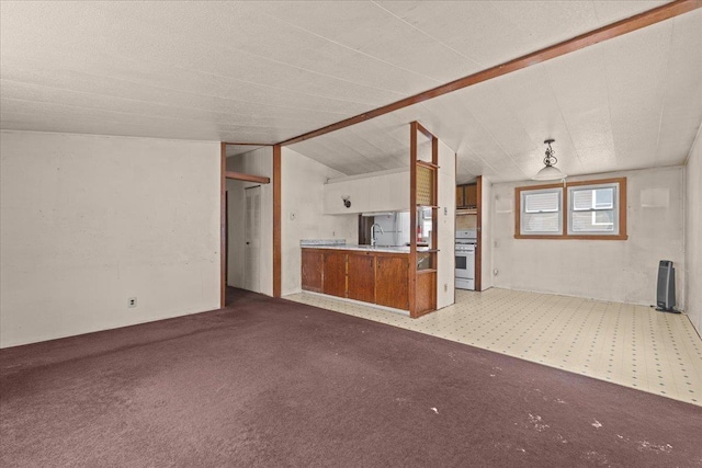 unfurnished living room featuring lofted ceiling, sink, and light colored carpet