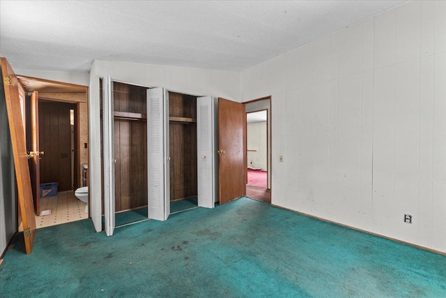 unfurnished bedroom with lofted ceiling and dark colored carpet