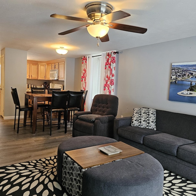 living room with dark wood-type flooring and ceiling fan