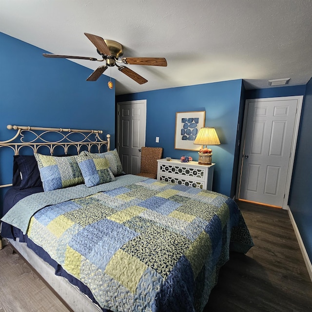 bedroom featuring hardwood / wood-style flooring, ceiling fan, and a textured ceiling