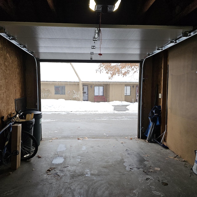 snow covered garage with a garage door opener