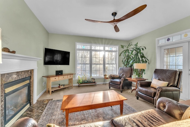 living room featuring ceiling fan, a healthy amount of sunlight, a fireplace, and carpet