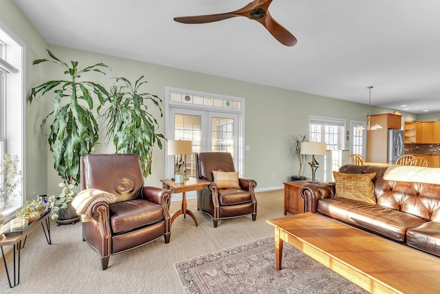 living room with light colored carpet, french doors, and ceiling fan