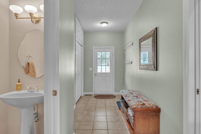 doorway to outside with sink and light tile patterned floors