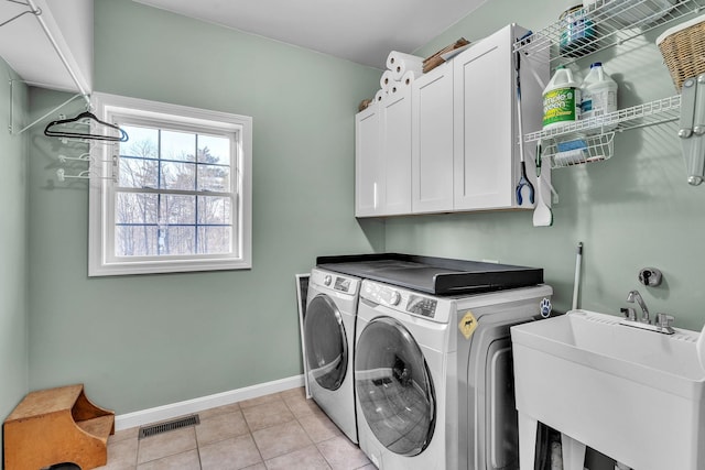 laundry room with washer and dryer, sink, light tile patterned floors, and cabinets