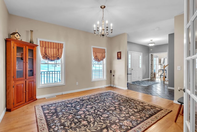 entryway with light hardwood / wood-style flooring and a notable chandelier