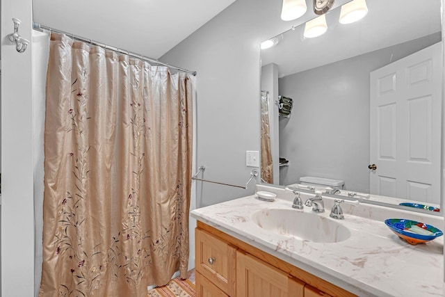 bathroom featuring vanity, toilet, and walk in shower