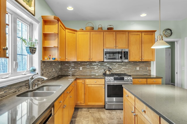 kitchen with sink, tasteful backsplash, decorative light fixtures, dark stone countertops, and stainless steel appliances