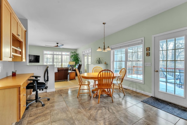 dining space featuring ceiling fan with notable chandelier