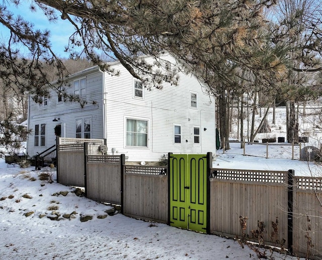 view of snow covered back of property