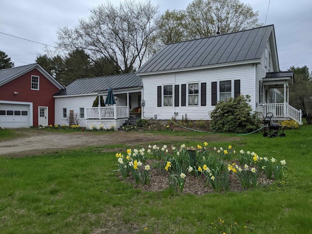 view of front of property featuring a garage, a front yard, and a porch