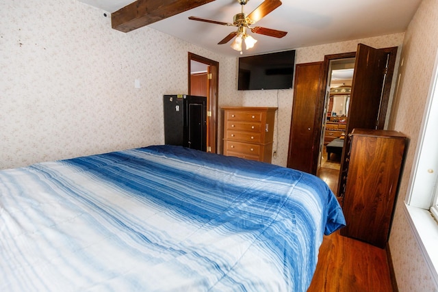 bedroom featuring beam ceiling, dark hardwood / wood-style floors, and ceiling fan