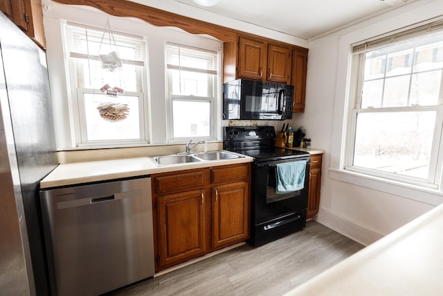 kitchen with sink, light wood-type flooring, and black appliances