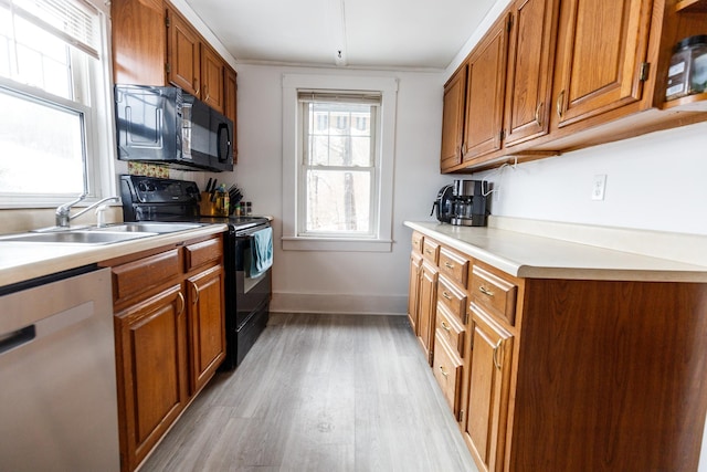 kitchen with light hardwood / wood-style floors, sink, and black appliances